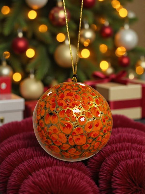 Gyllen julekule med oransje blomster